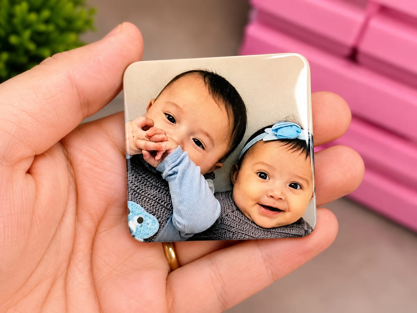 Ímã personalizado com foto de dois bebês sendo segurado na mão